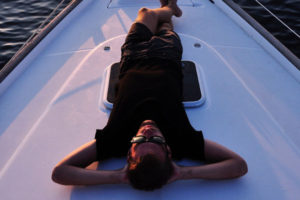 man laying on the deck of a sailing boat
